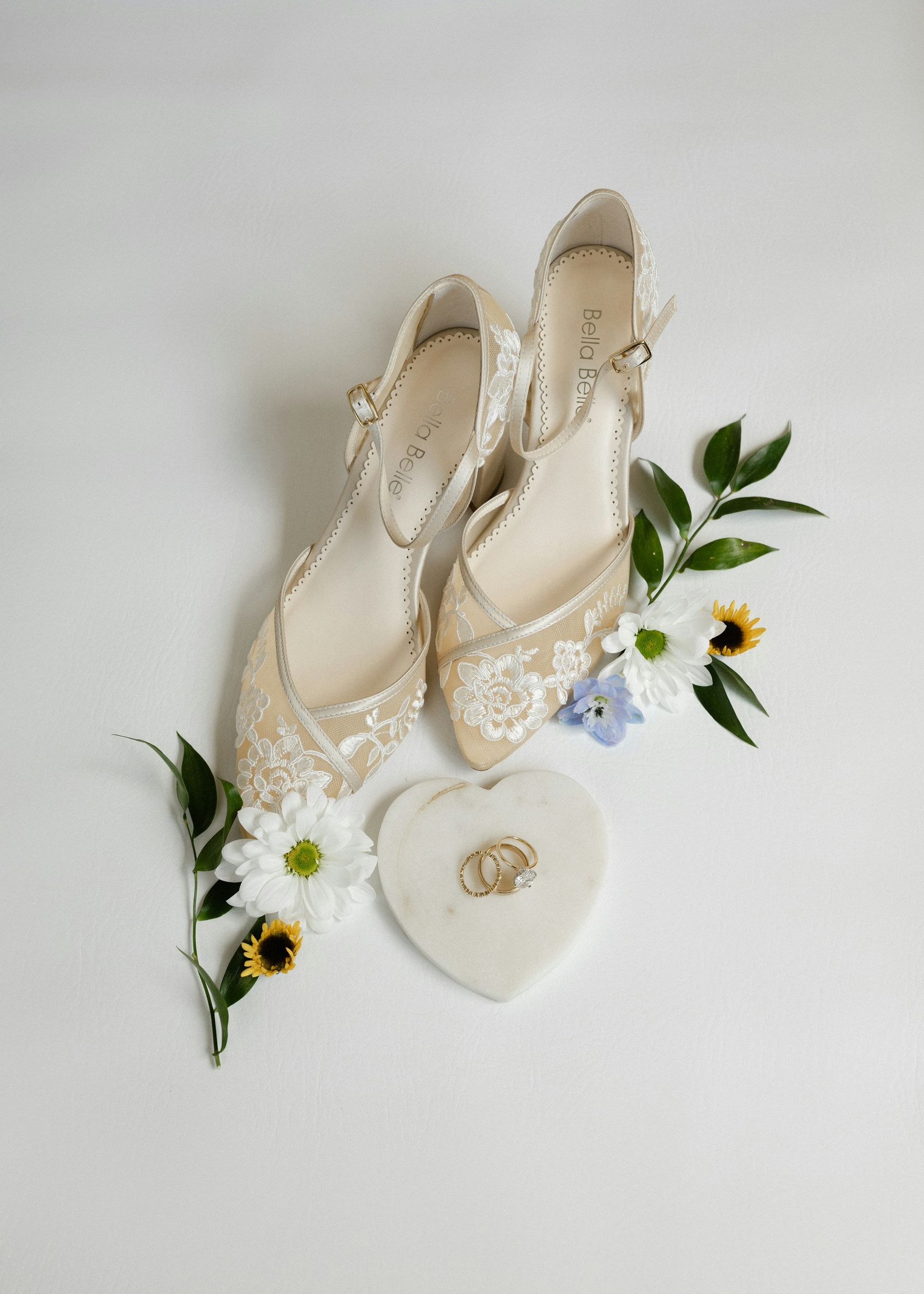 Les chaussures de la mariée, quelques fleurs des champs et une boîte à alliances en forme de cœur