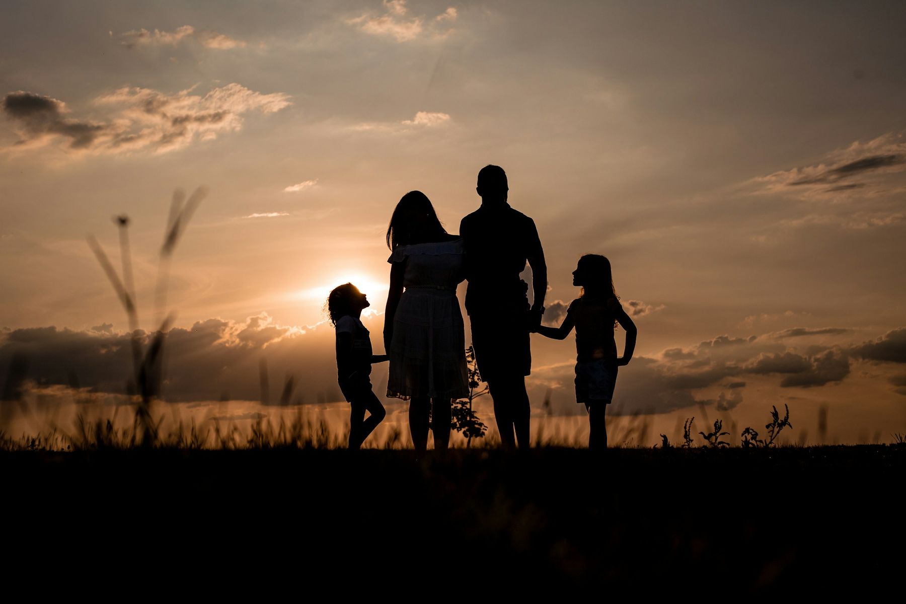 La silhouette d’une famille main dans la main au coucher du soleil
